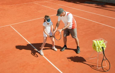 Zelfklevend Fotobehang Tennis coach with talented young girl © Microgen