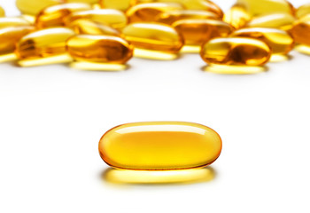 Close up one capsule Omega 3 and many other of capsules isolated on white background. High resolution product. Health care concept