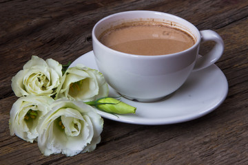 Still life with cup of coffee and flowers Eustoma on wooden background