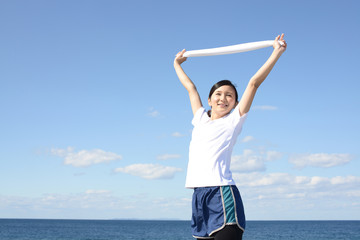 Obraz premium 海岸でストレッチをする女性