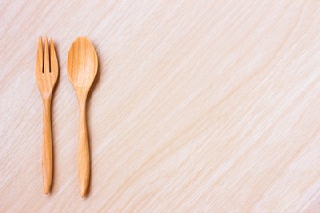 Wooden spoon and fork on wood table / copy space / top view