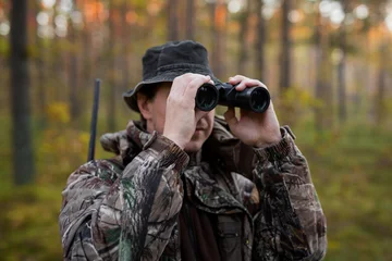 Rolgordijnen Jacht Hunter looking into binoculars
