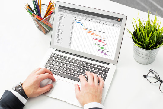 Businessman using project management software on compter