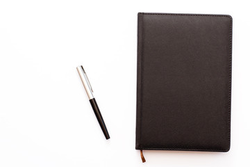 black diary and pen on a white background