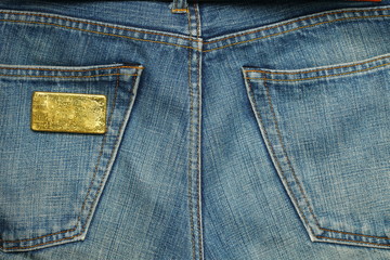 The gold bar put in the jean pocket background represent gold and business finance concept related idea.