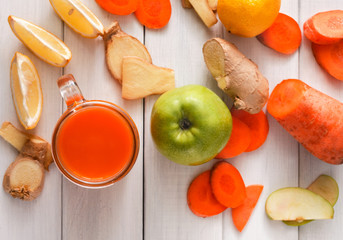 Natural detox carrot smoothie ingredients, top view on white background