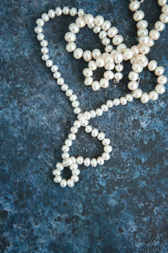 White pearl necklace on a blue backround
