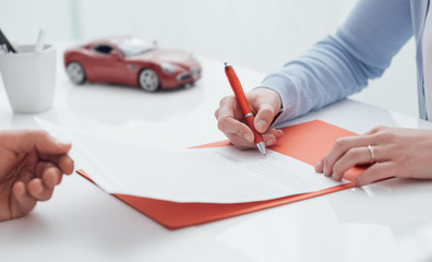 Driver signing a car insurance