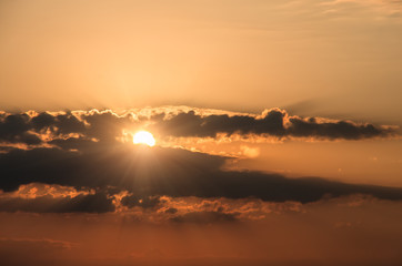 sun behind clouds sunset , natural background