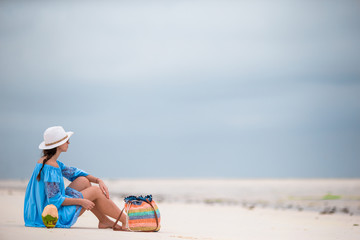 Back view of young beautiful woman on the beach during low tide