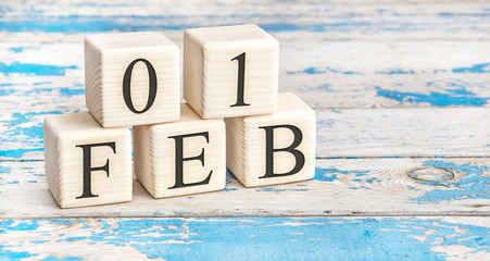 February 1th. Wooden cubes with date of 1 February on old blue wooden background.