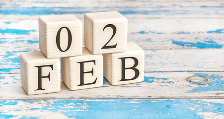 February 2nd. Wooden cubes with date of 2 February on old blue wooden background.