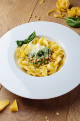 pasta with leaves basil on wooden desk