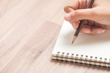 Business women hands working writing notebook on wooden desk, lighting effect