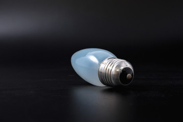 economical light bulb on a black background.