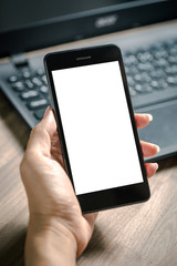 Business women hand holding smart phone to working with laptop