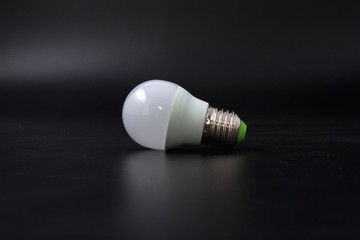 economical light bulb on a black background.