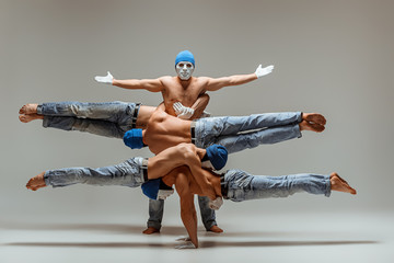 The group of gymnastic acrobatic caucasian men on balance pose