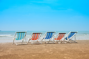 Group of empty deck chairs on sea beach. Vacation with friends concept