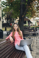 Student girl working with a laptop in old city