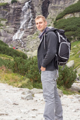 tourist man in nature with waterfall