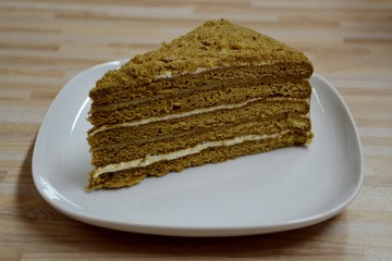 Detail from a homemade honey cake and white plate