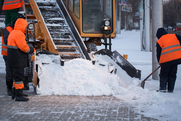 Tractor cleaning the road from the snow. Excavator cleans the streets of large amounts of snow in...