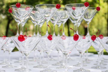 Close-up of the champagne pyramid with a red cherry at the top of each glassGlass goblets. Pyramid of champagne. A celebratory drink. Decorations for the Banquet.