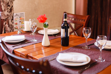 Dinner in the restaurant. Cutlery, wine and a rose on the table