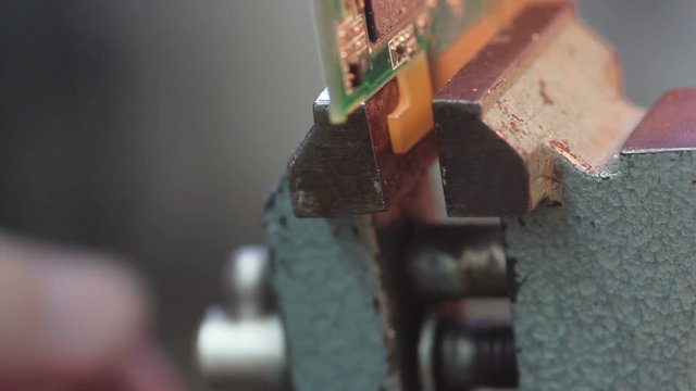 Put electronic circuit in the vise for dismantling