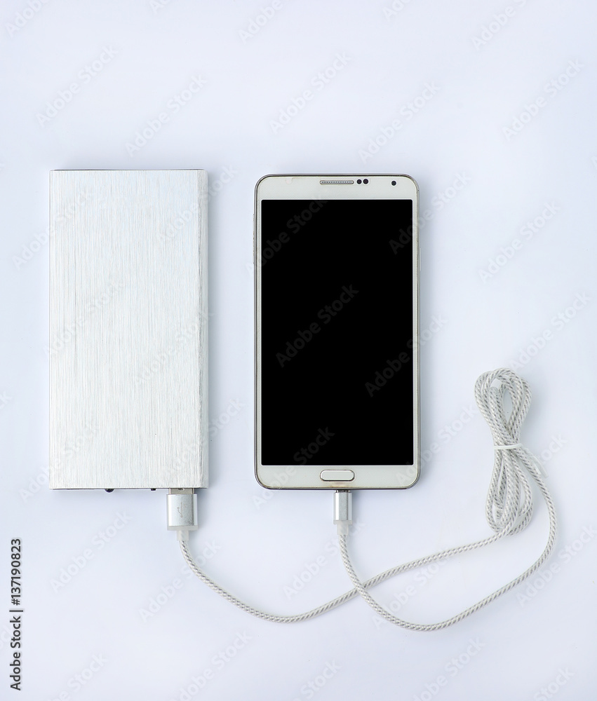 Wall mural smartphone charging with power bank on white background