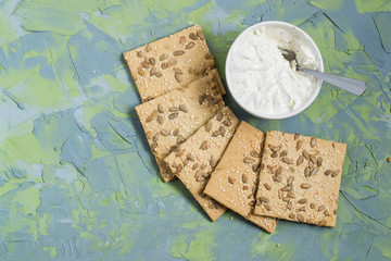 Fototapeta na wymiar Homemade crackers with sesame, sunflower seeds and cream cheese