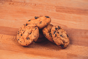 Home made chocolate cookies on wooden background. Crispy chip biscuits with chocolate and hazelnuts. Delicious fresh chocolate chip cookies.