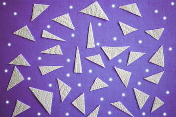 Abstract background with triangular pieces of paper on purple cloth