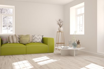 White room with sofa and winter landscape in window. Scandinavian interior design