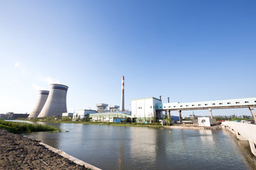 Obraz premium modern power plant near river in blue sky