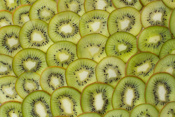 Bright green background with slices of juicy kiwi. Healthy food background.