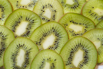 Bright green background with slices of juicy kiwi. Healthy food background.