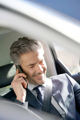 Businessman talking on phone in taxi cab