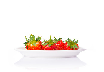 fresh red stawberries in a white plate on isolated white background