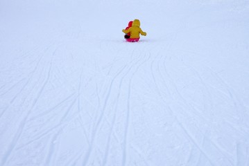 スキー場でそりで遊ぶ子ども