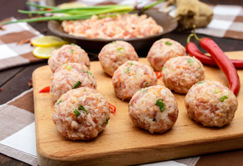 Raw meat balls, ready for cooking on a cutting board. Close up