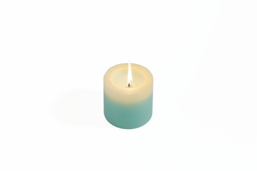 A lit scented candle on a white background