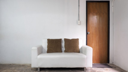 White leather sofa and white old wall.