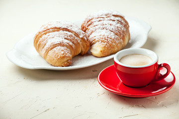 Cup of coffee and fresh croissants