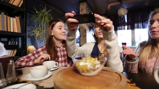 Female friends taking food picture with smartphone