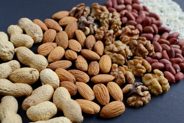 Assorted mixed nuts, peanuts, almonds, walnuts and sesame seeds.  Black background
