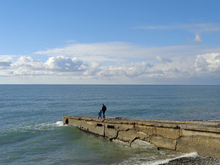 Father and son walking along pier to the sea
