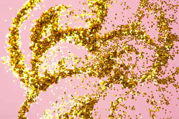 Golden glitter bokeh on pink background.