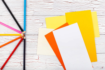 The colored pencils and papers stand on the table